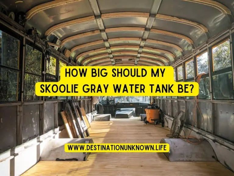 An interior photo of a gutted school bus interior, after the seats and panels have been removed. The text reads "how big should my skoolie gray water tank be?"