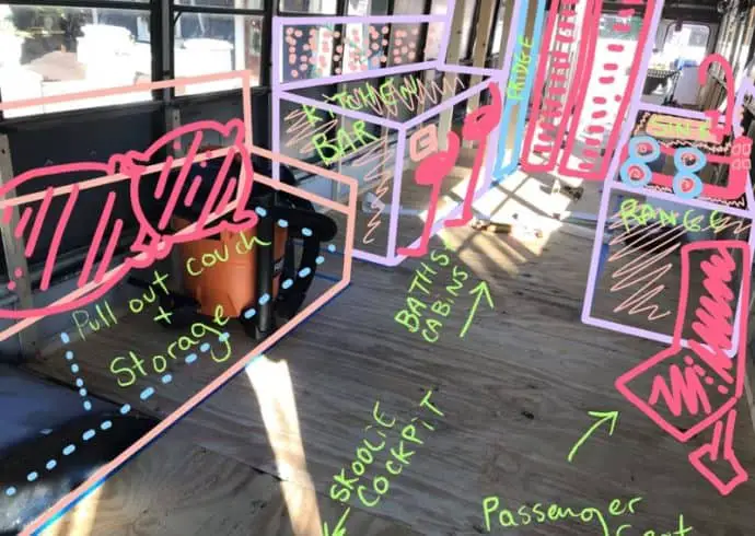 The image is a skoolie build out at the framing stage. The owner took an interior photo and then used the procreate app on her ipad to draw the layout of the kitchen and living room. The text on the "furniture" states what it is like "pull out couch and storage."