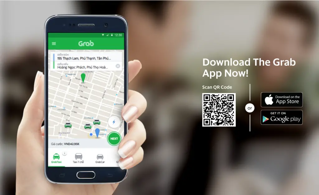 image of a woman's hand holding a cell phone. On the cell phone is an email of the Grab app.
