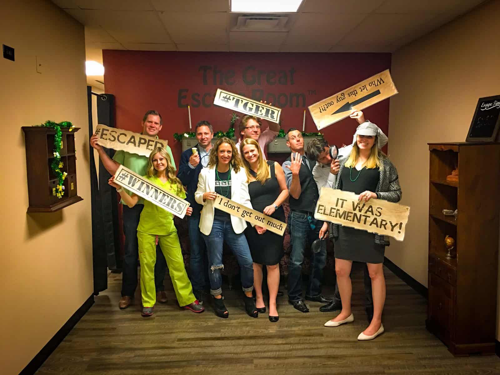 Group of friends smiling after completing a Sherlock Holmes Themed Escape room in Downtown Tampa at The Great Escape Room.